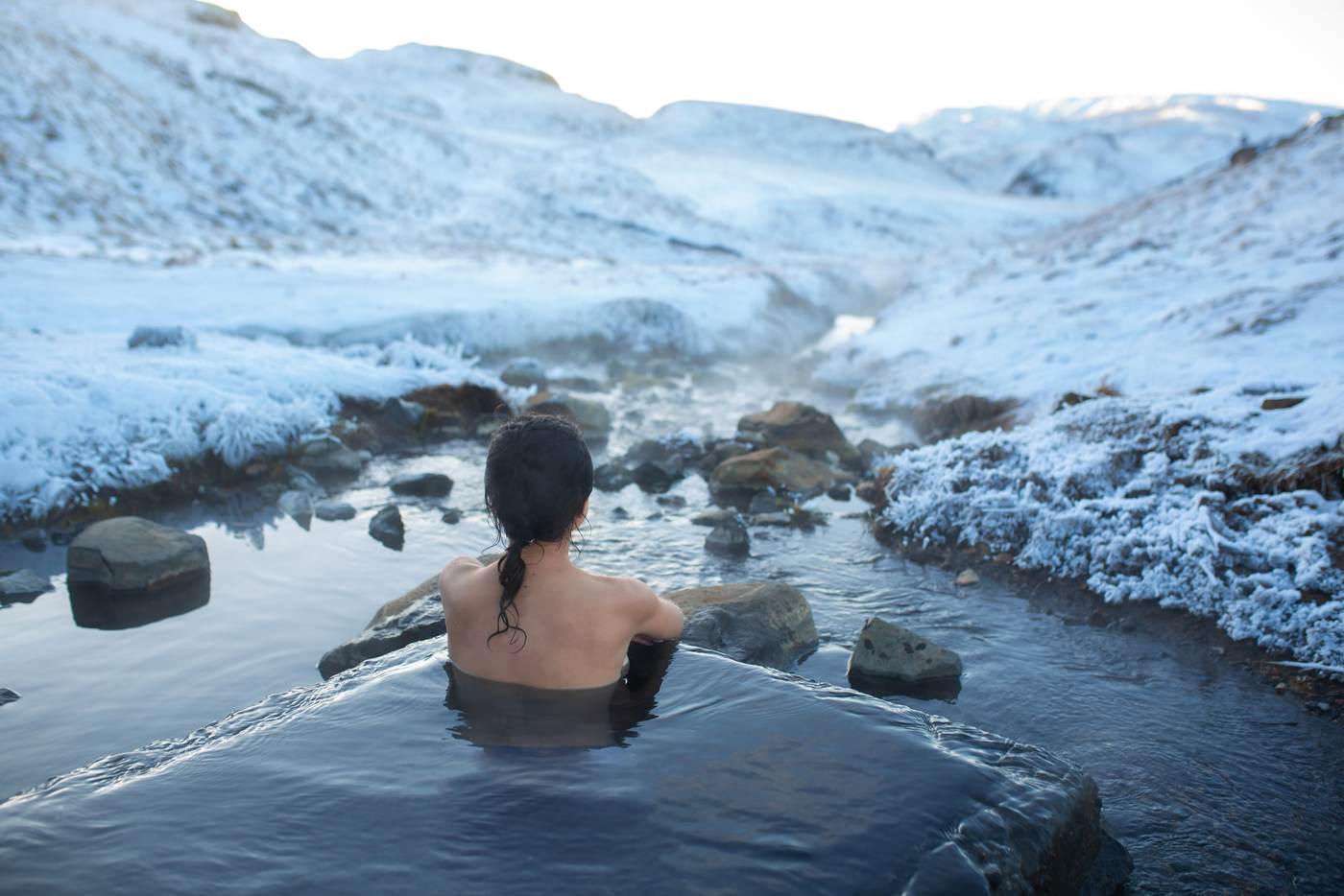 A guest relaxing in a cold pool surrounded by snow